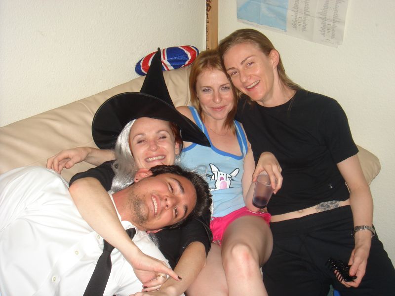 three people sitting together on a couch smiling