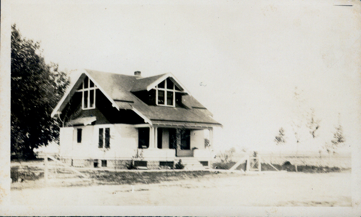 old time picture of a house with a white chimney and large windows