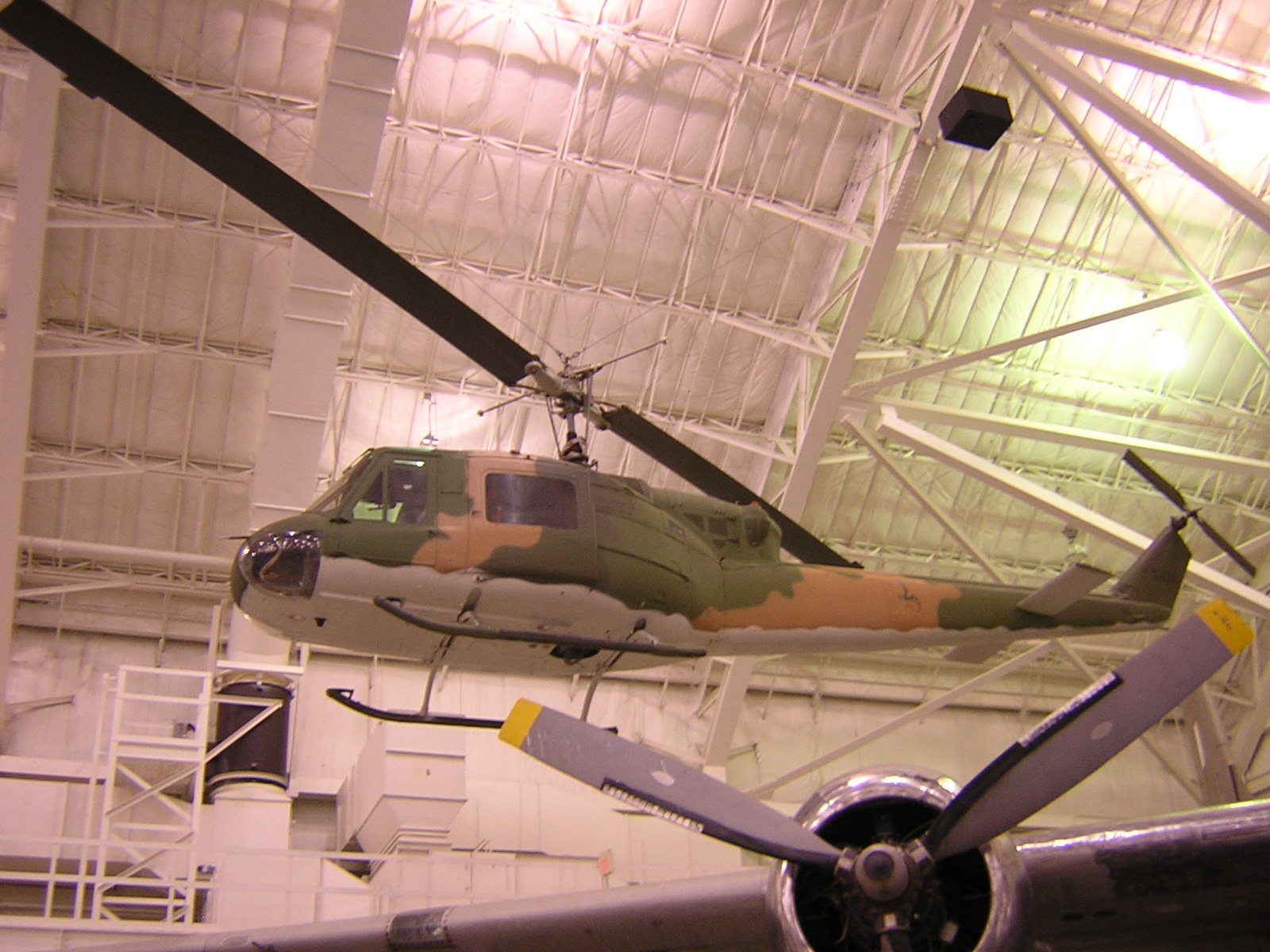 a small military helicopter is on display in a hanger
