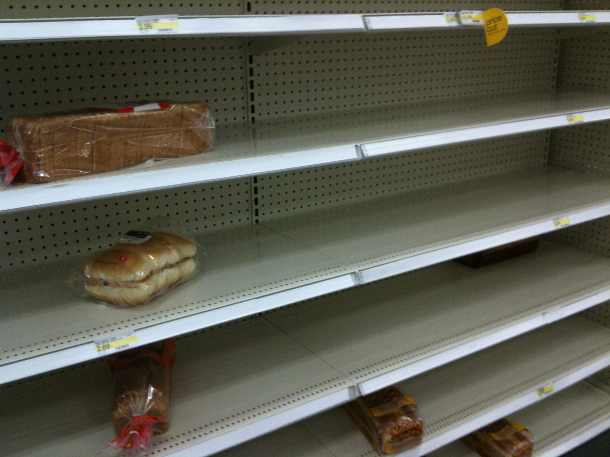 a store shelf containing bread and croissants