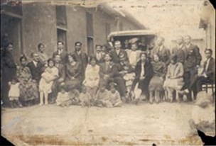 an old pograph shows a group of people standing in front of a bus