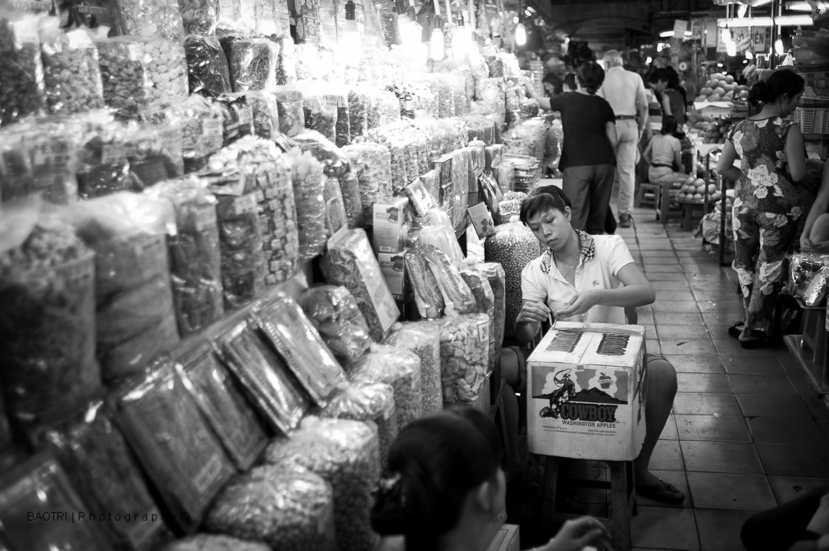 black and white pograph of people in a market selling goods