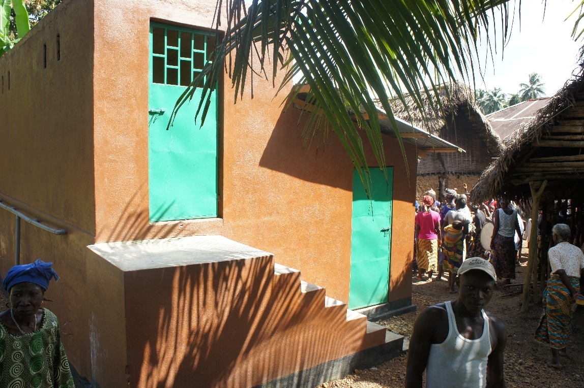 the people are standing outside of a small building