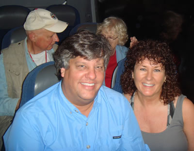 a man sitting next to a woman in front of a bus