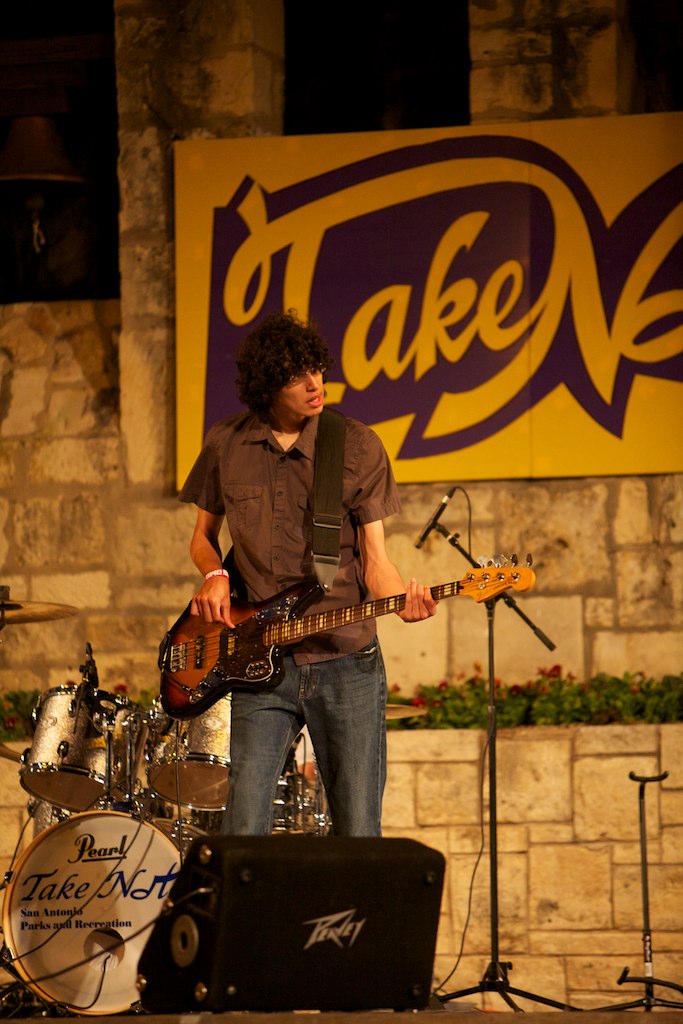 a person playing guitar in front of a microphone and other instruments