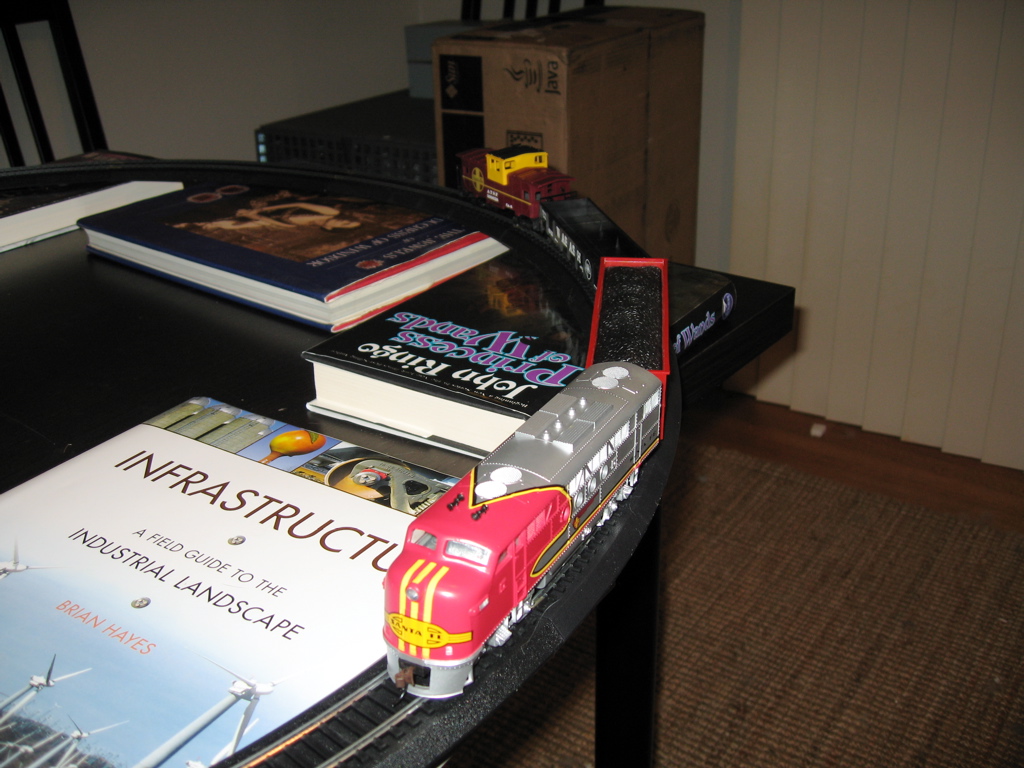 several books are on a table with a toy train