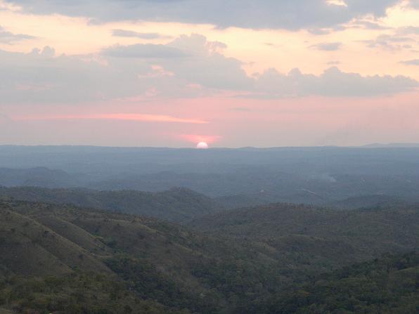 an image of a sun set in the distance from a mountain