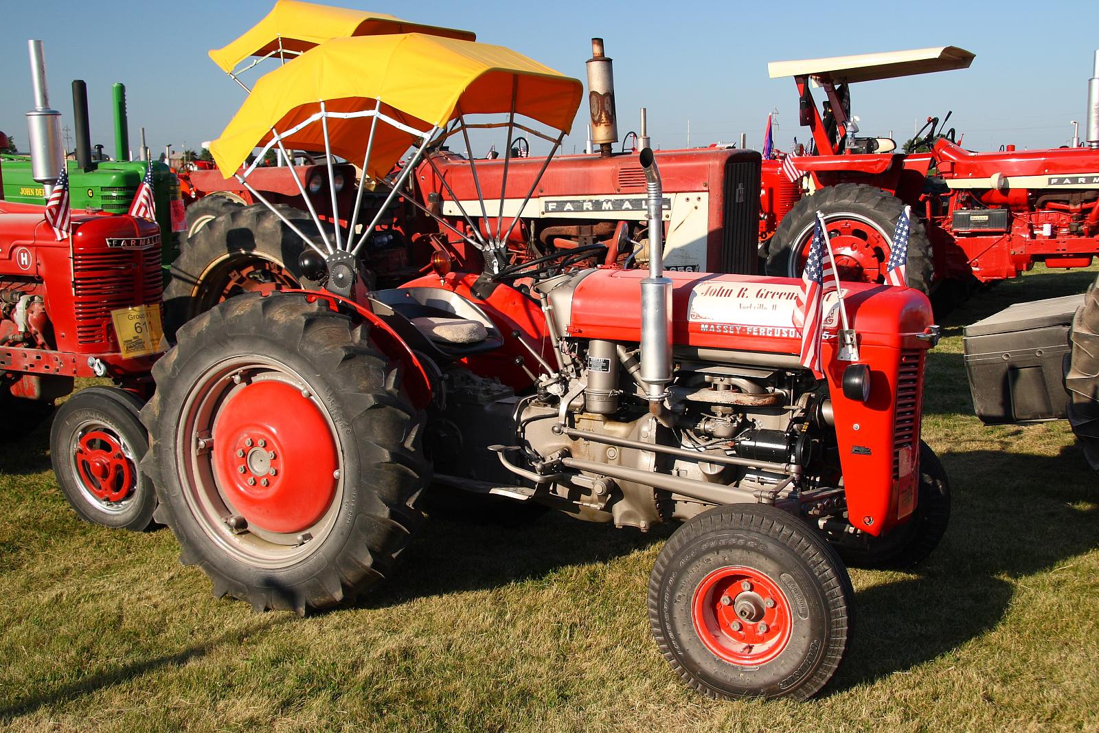 several farm tractors on display on some grass
