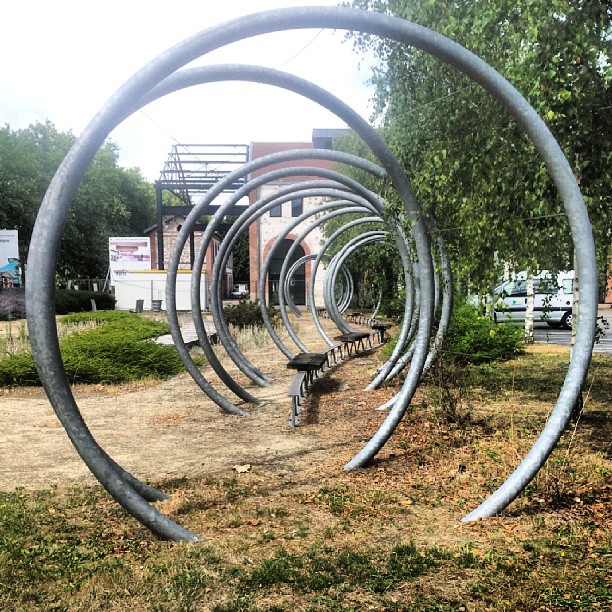 several large metal rings standing in an area of grassy area