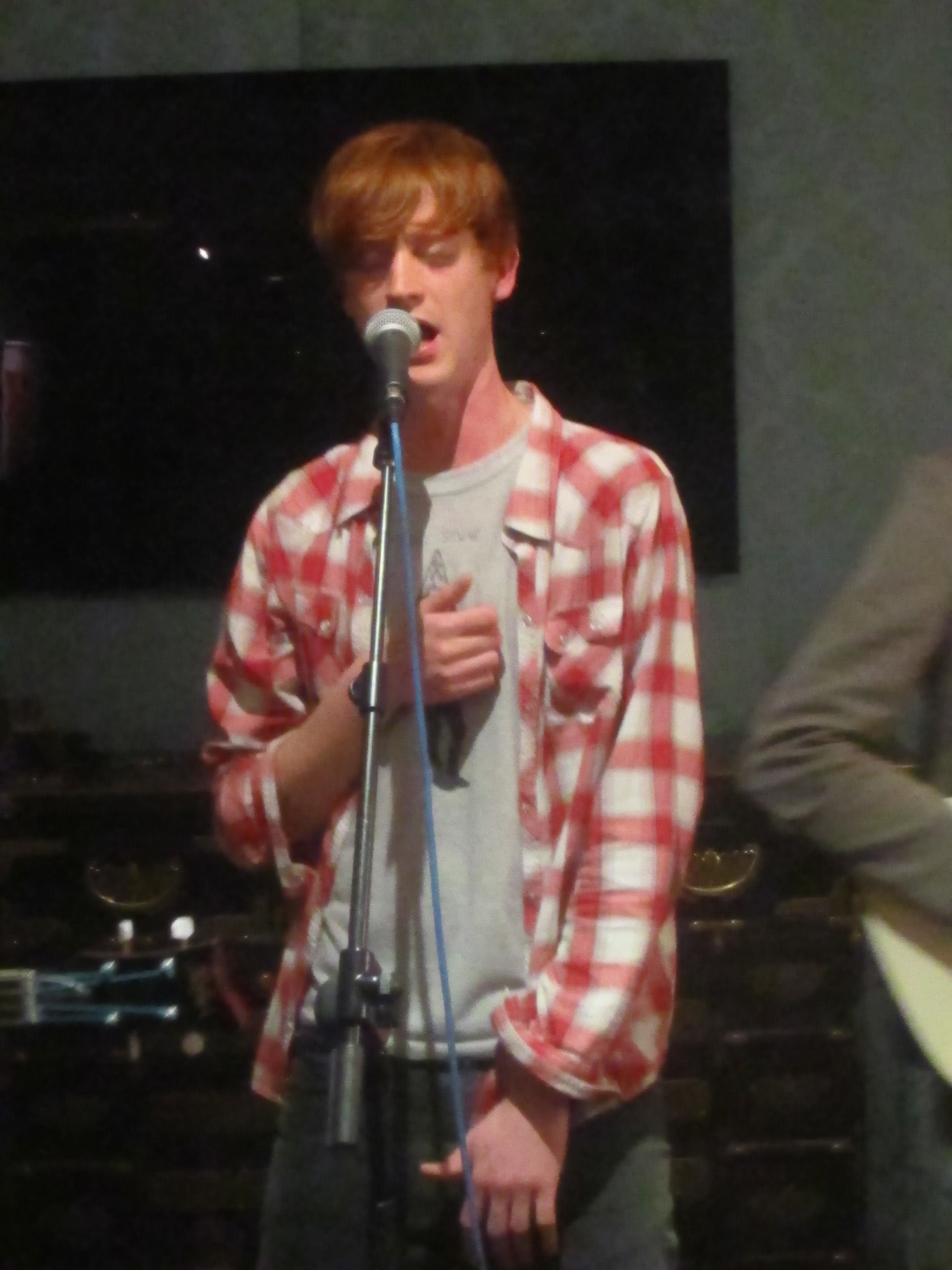 the young man is singing into a microphone