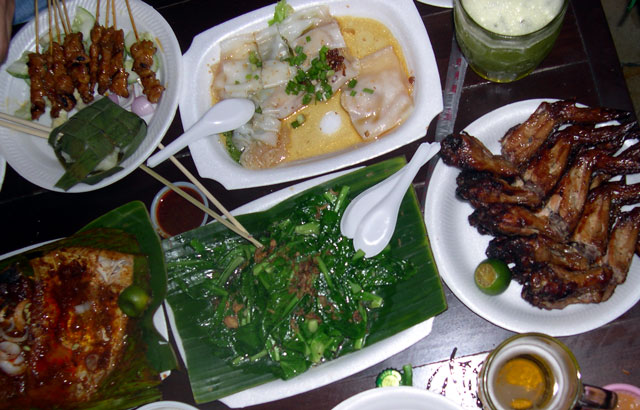 a table with white plates of meat, greens and rice