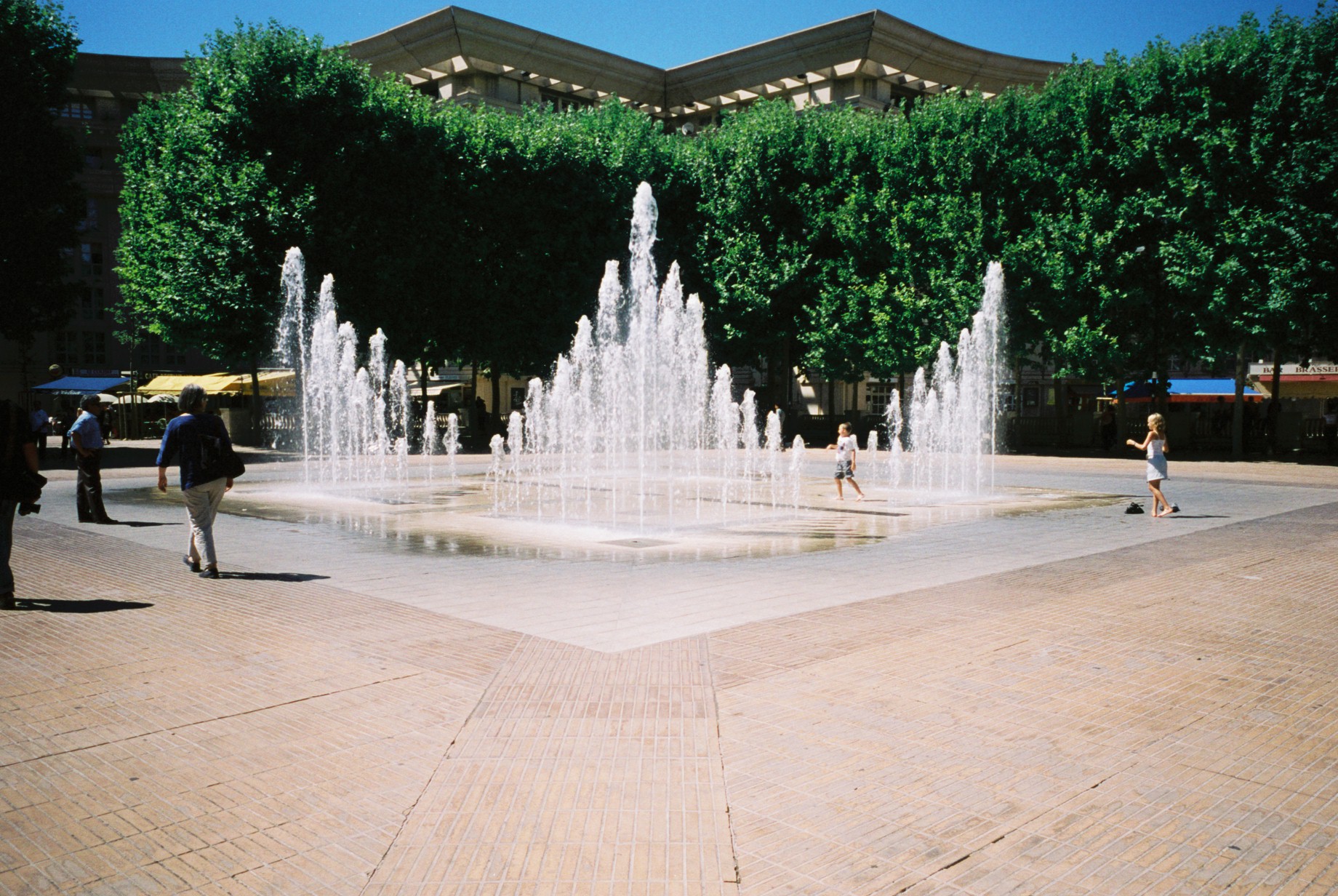 a view of two fountains in the center of a plaza