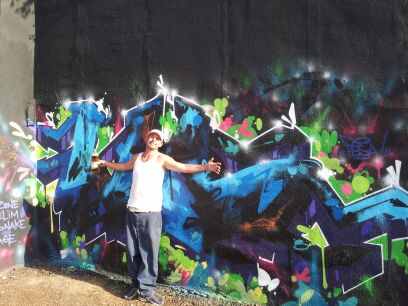 a person stands next to a wall that is covered with graffiti