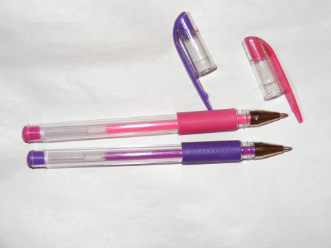 three pens are sitting on top of a white sheet