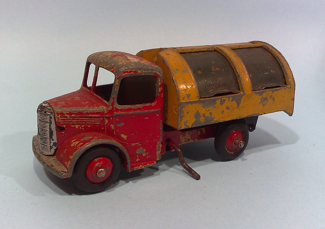 an antique yellow and red dump truck with a trailer attached