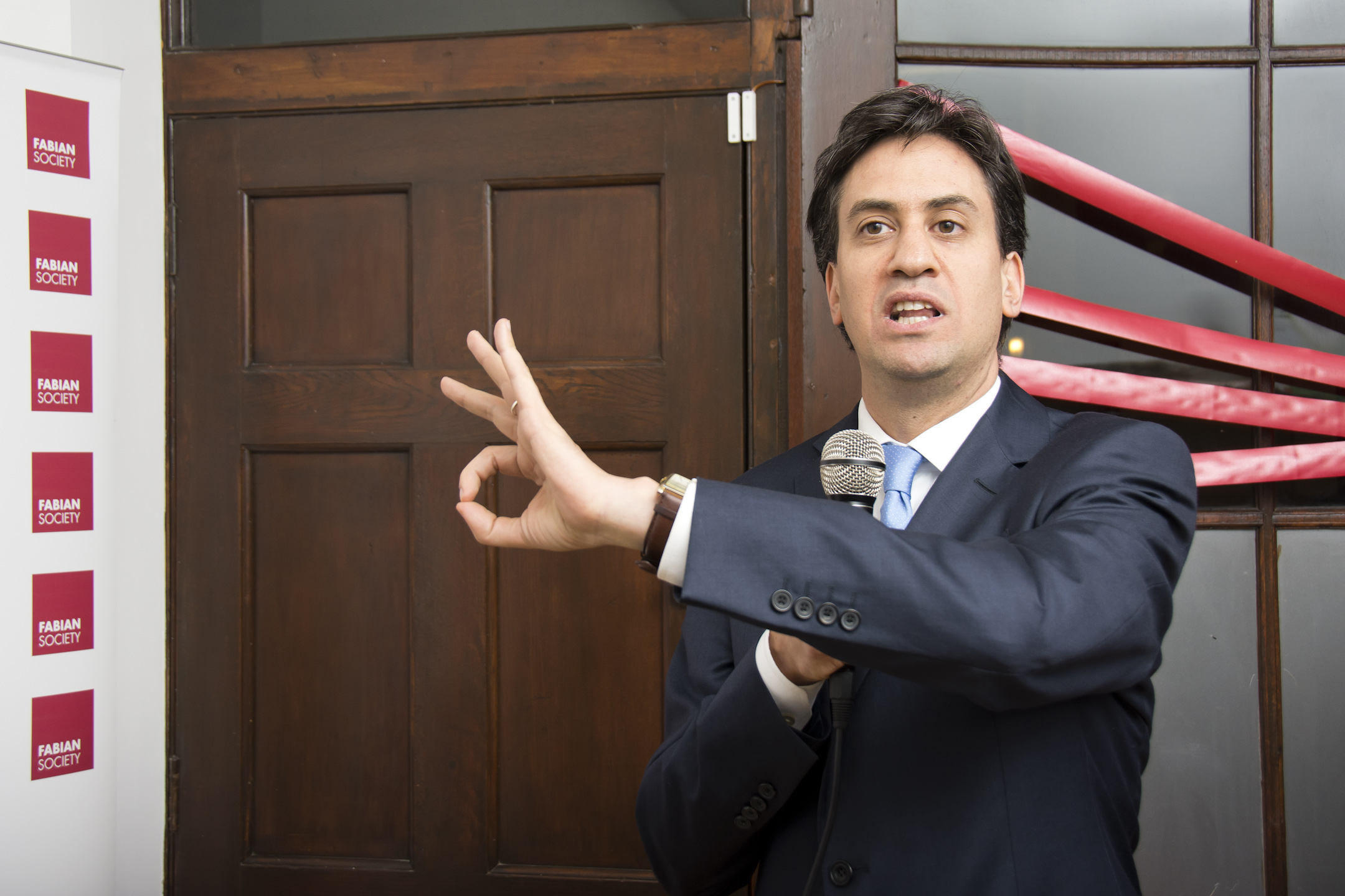 man in suit posing with arms outstretched and fingers spread out