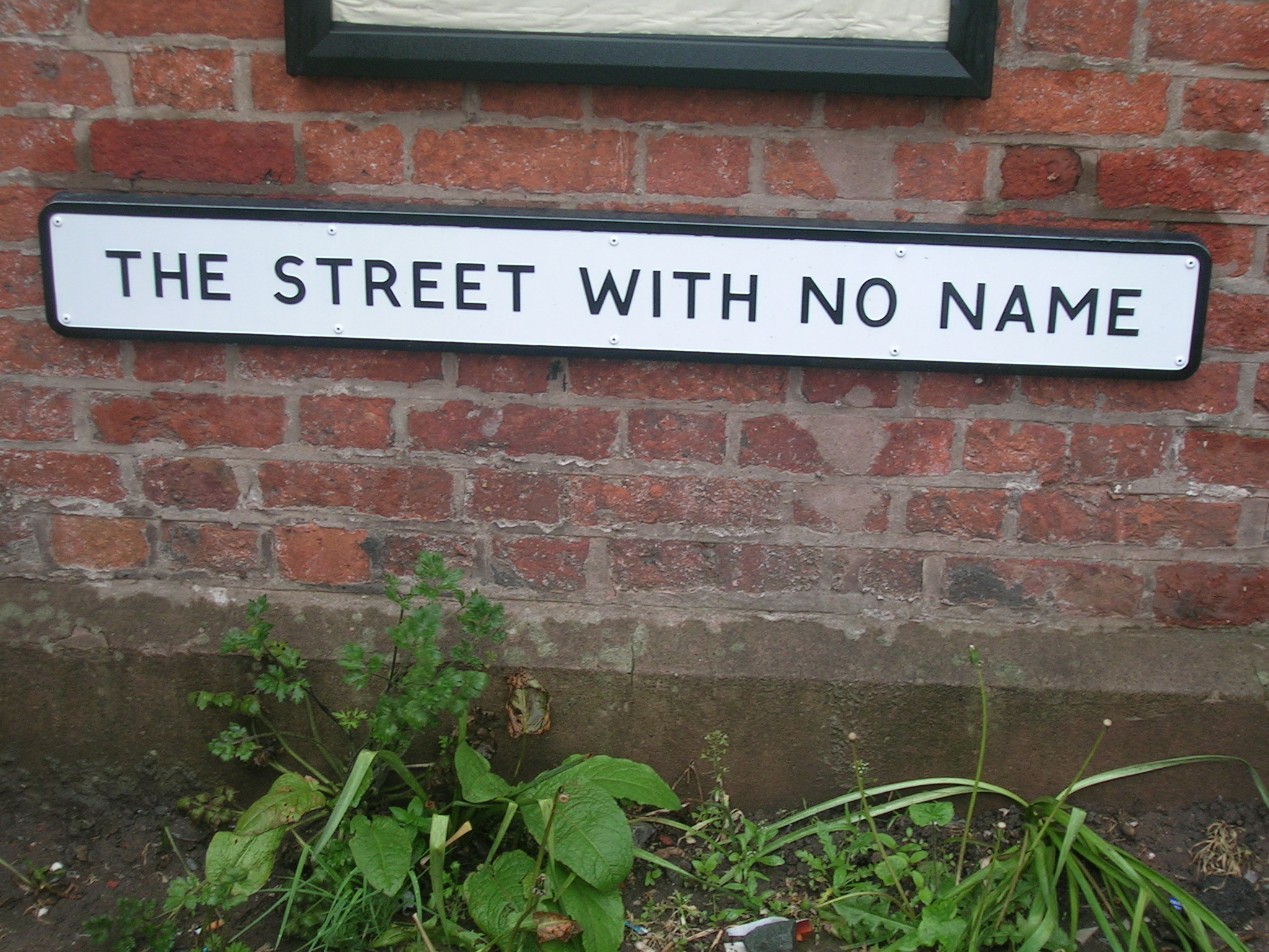 a street sign posted to the side of a brick building