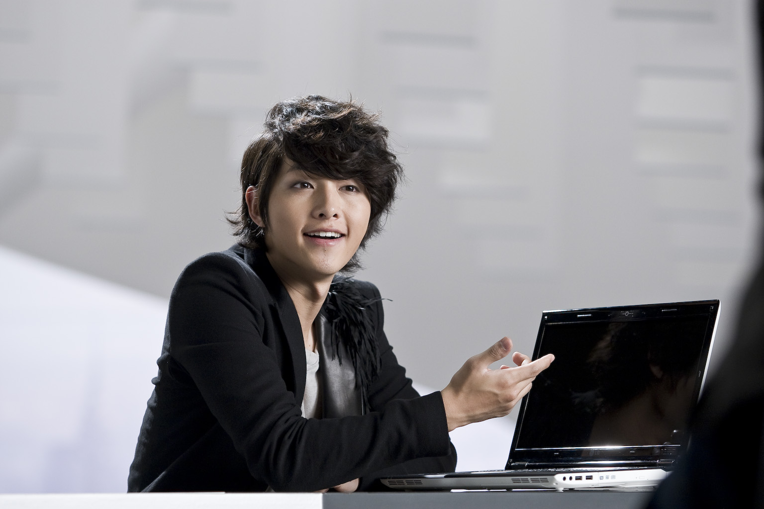 a woman holding a laptop and standing in front of her