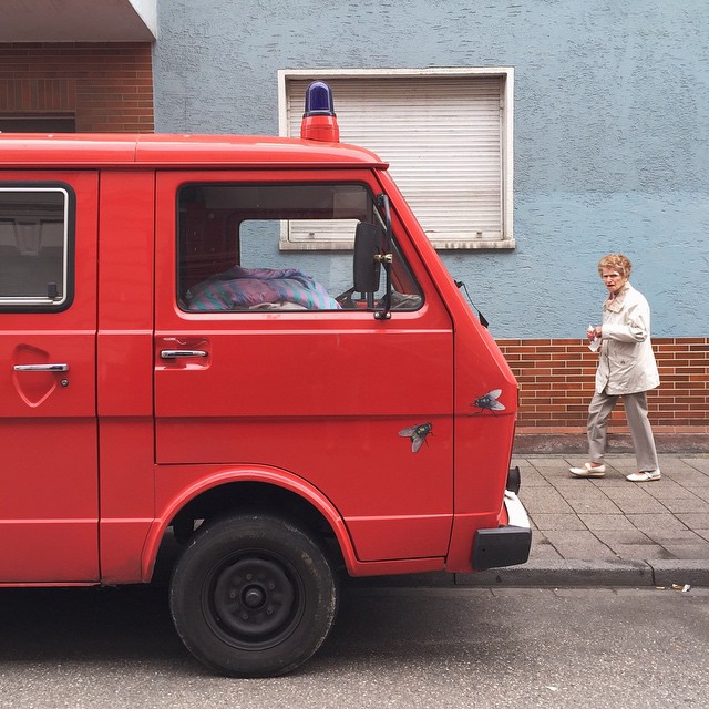 a man is walking near a parked red van