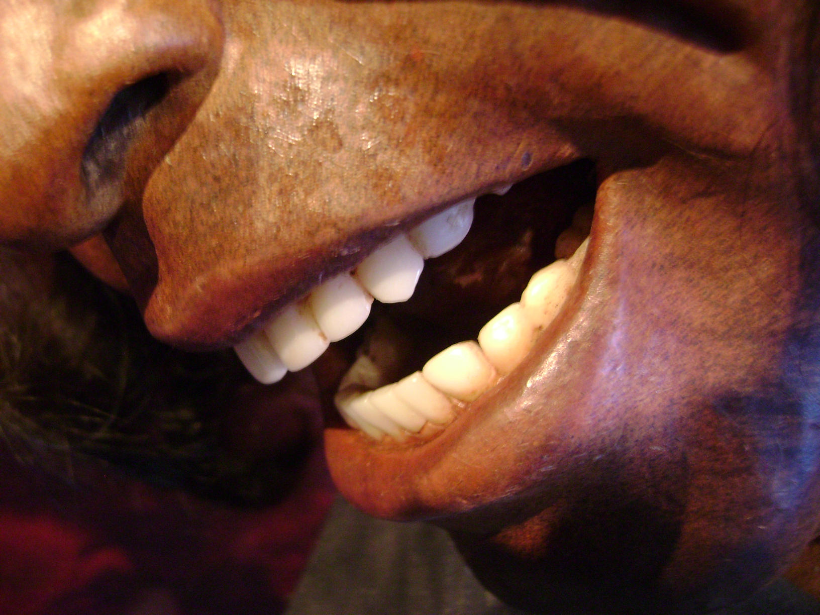 a wooden figure with teeth smiling in it