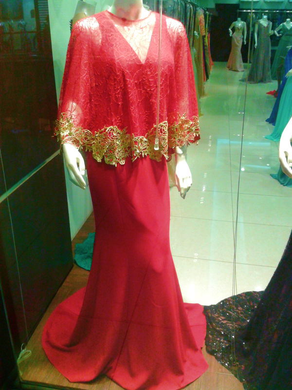 a red gown with gold detailing and cape