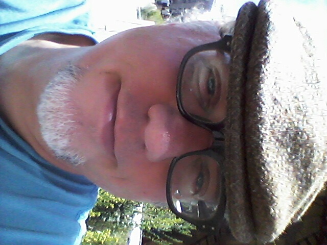 a close up of a man wearing glasses and a hat