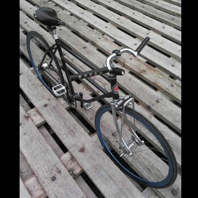 a bike with a black seat resting on a wooden pallet