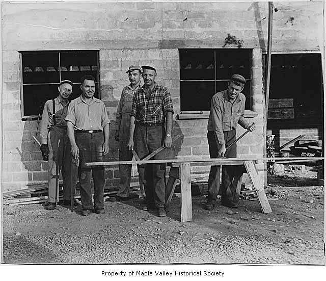 five men are posing for a picture on a construction site