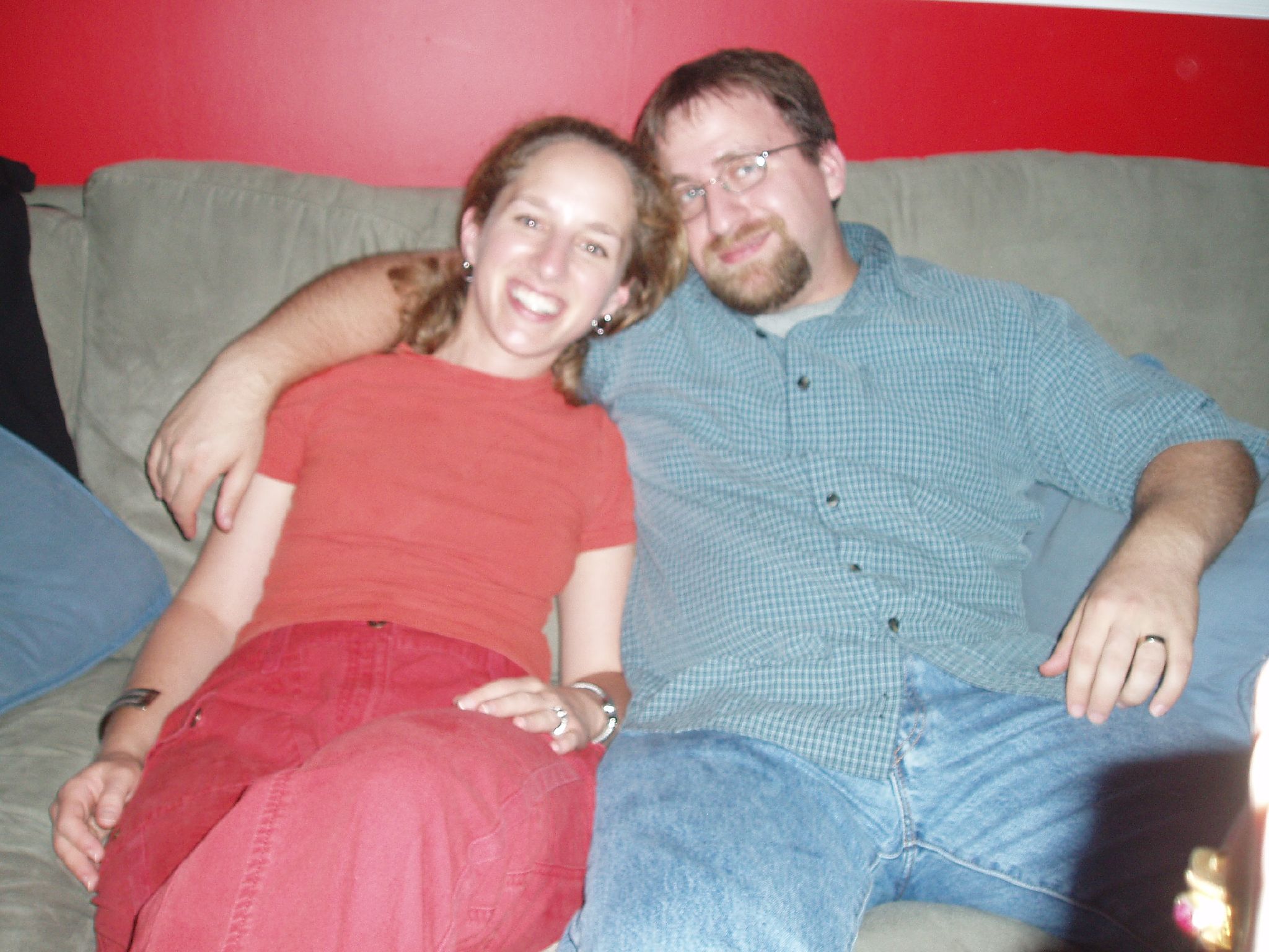 a man and woman sitting on top of a couch