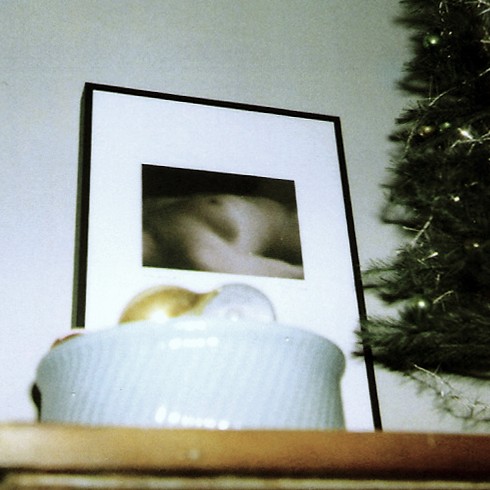 a cup on a table near a pograph of a baby