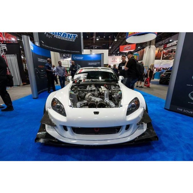 white sports car parked with its hood open on display