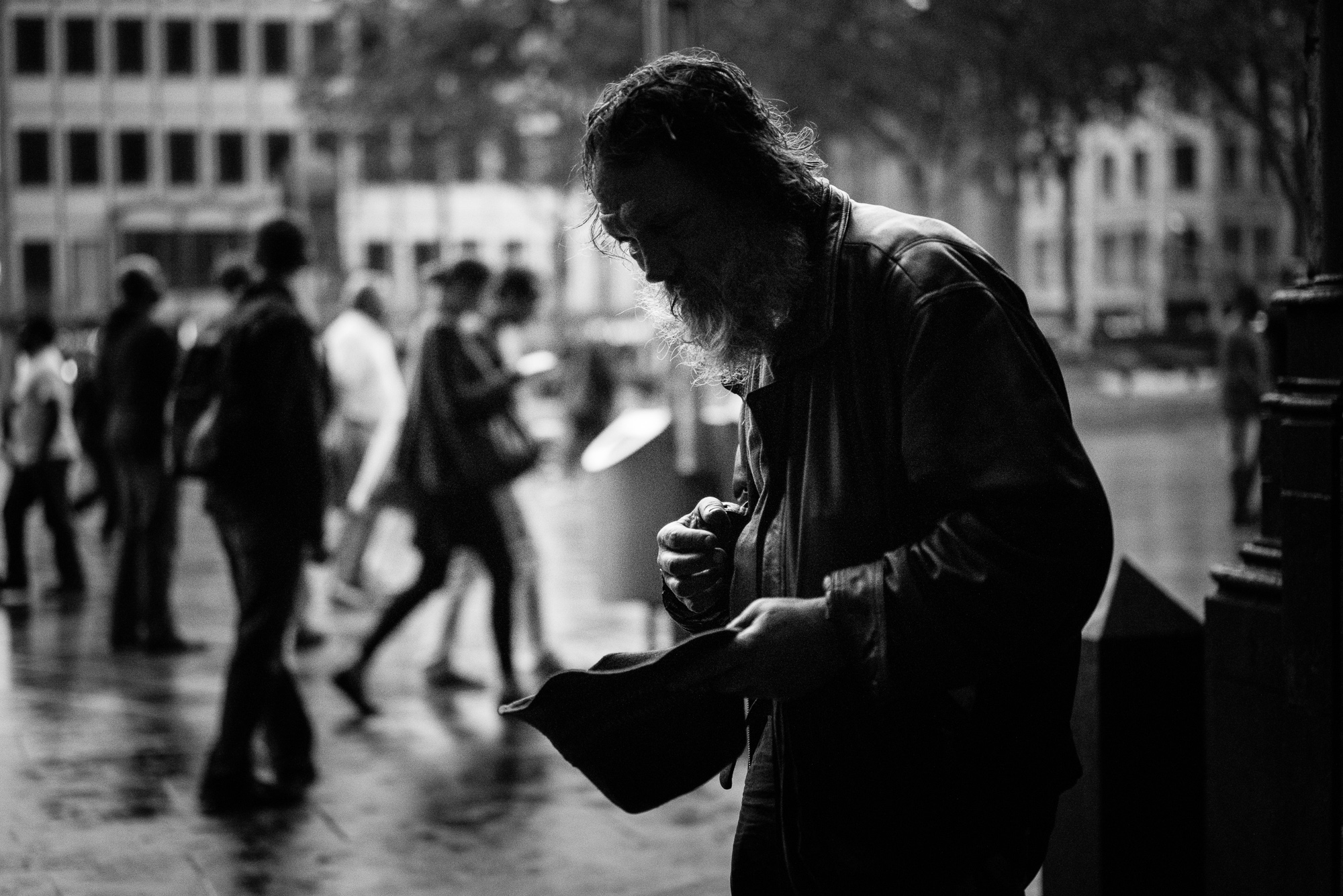 man in coat looking down at his cell phone