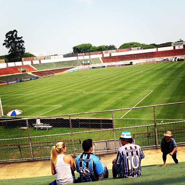 some people are sitting on the bleachers watching a soccer game