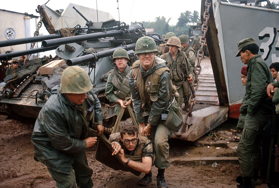 men in camouflage gear getting ready to step into a tank