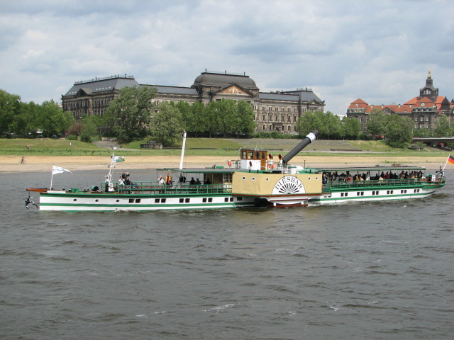 large green and white passenger boat with people on deck