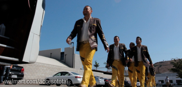 men wearing yellow pants and black jackets walking across the street