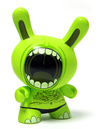 a green toy is showing its teeth and mouth