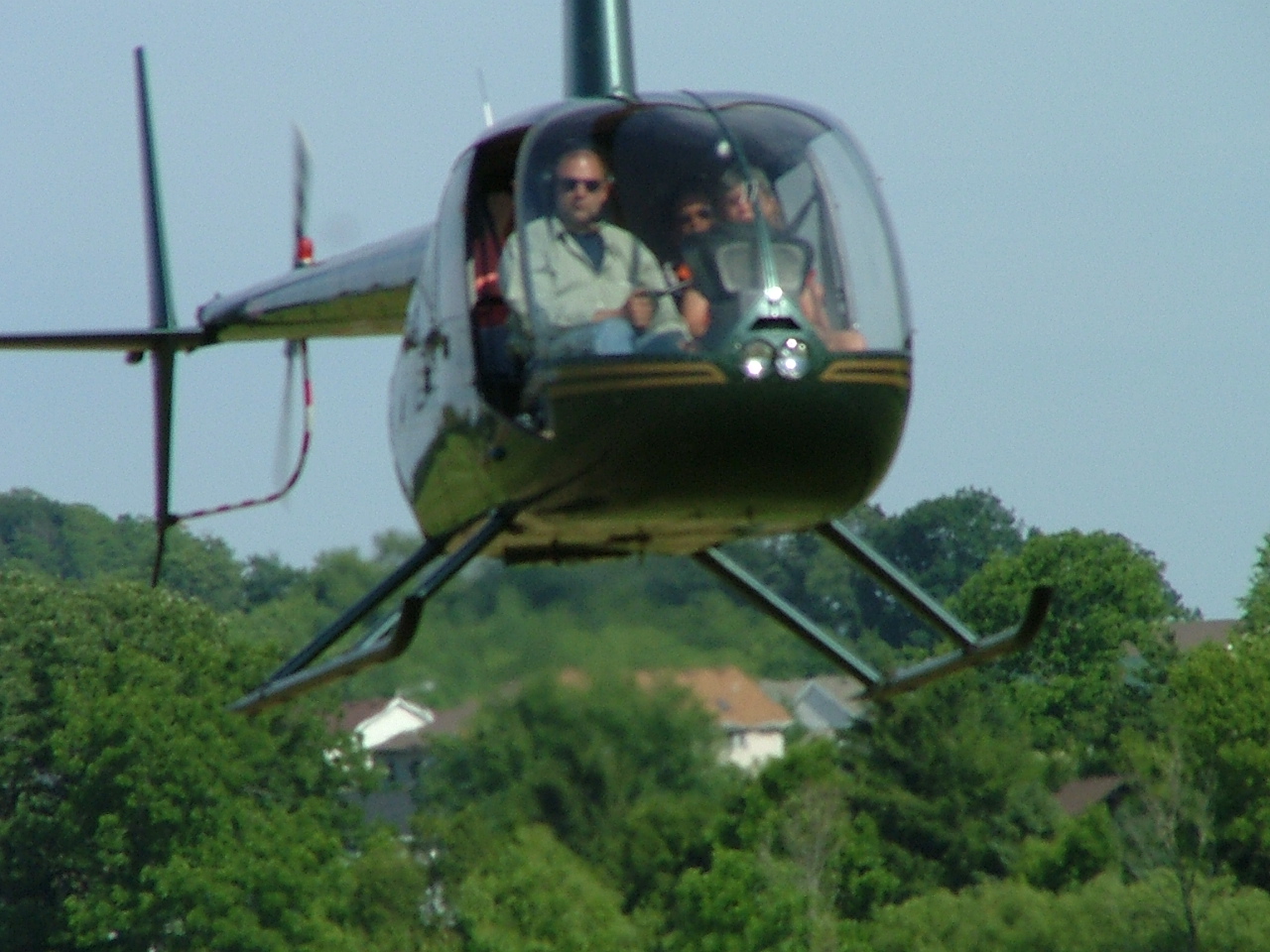 a helicopter with passengers flying over trees