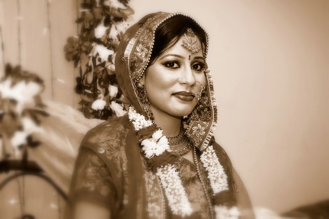 indian woman in bridal dress near flowers