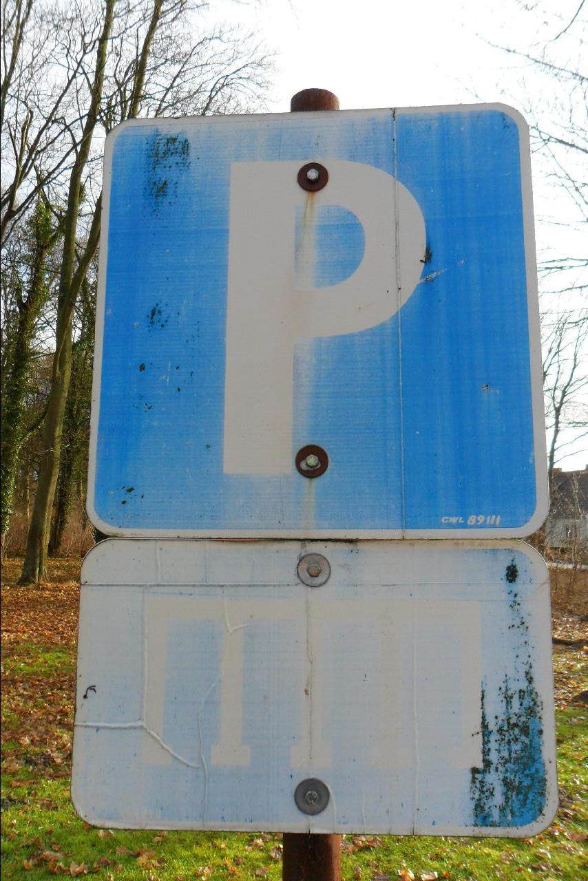 a blue sign with a white symbol on it and a pole with two holes