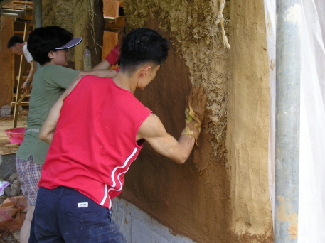 a man and a boy paint a wall outside