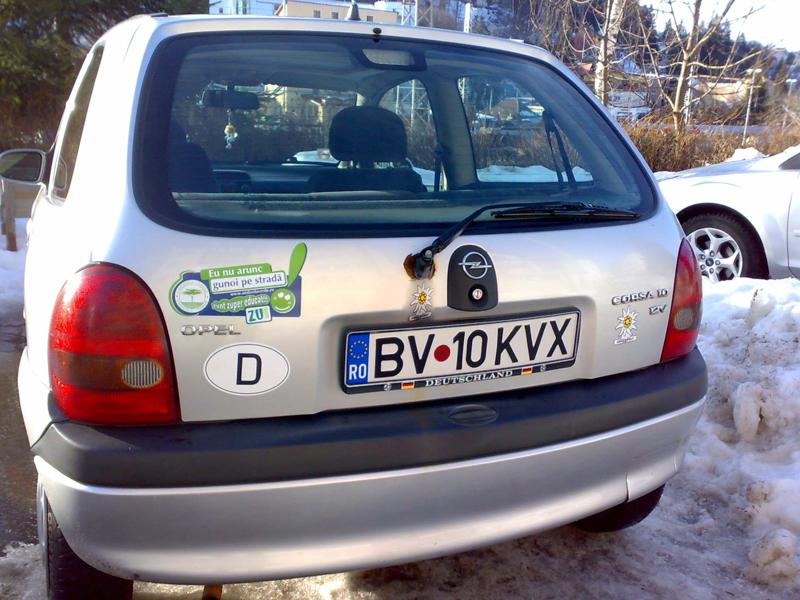 a parked white car with green stickers on it