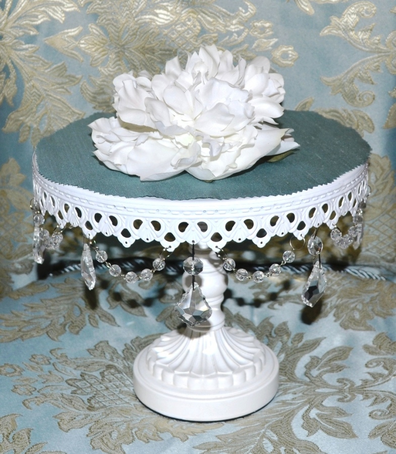 a white decorative flower sits on top of a round cake