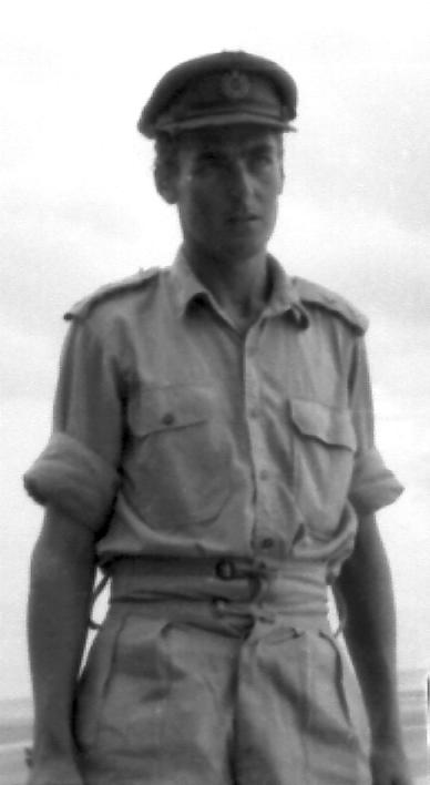 a man wearing a uniform standing next to the ocean