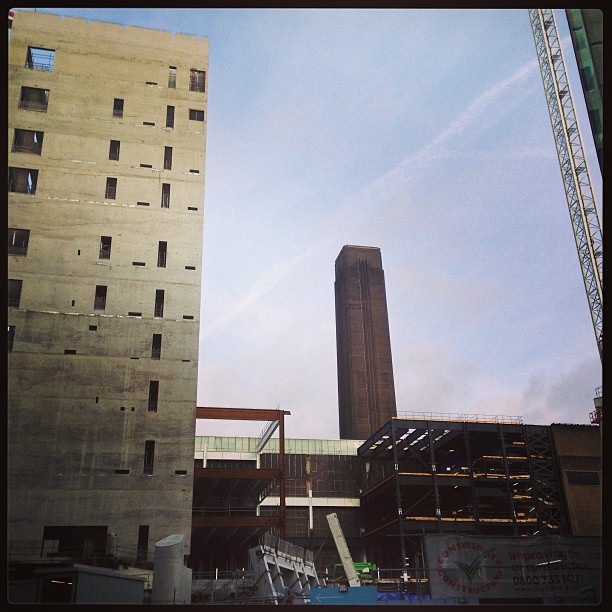 a view of an industrial area with a tall building and a crane