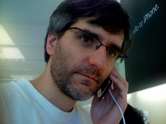 a man talking on a cell phone while wearing glasses