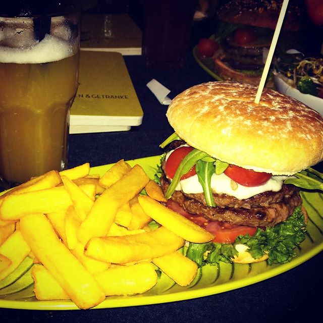 the plate has french fries, burger and beer on it