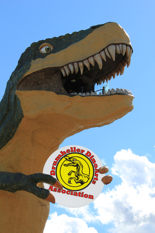 the logo of a dinosaur eating establishment with an open mouth
