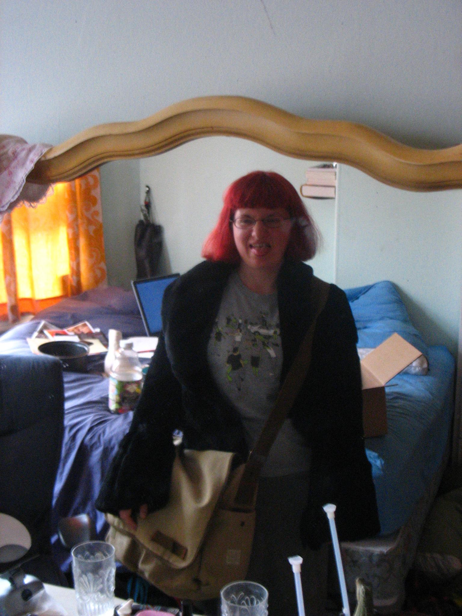 a woman with red hair and blue eyes taking a selfie in her bedroom