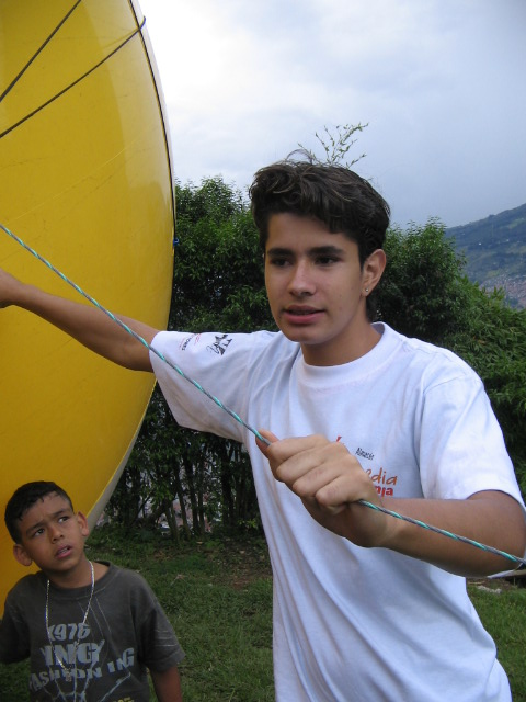 two men near a big yellow object that is in the air